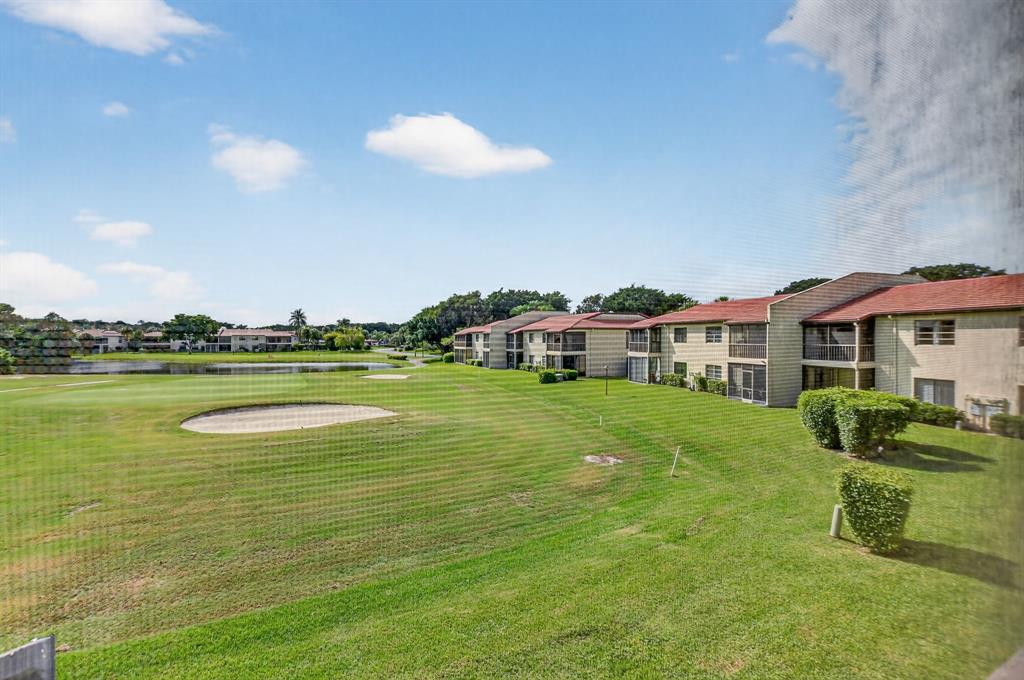 21219 Lago Circle, Unit J5 Boca Raton, FL 33433 - Photo 36 of 46 a front view of a house with a garden and lake view