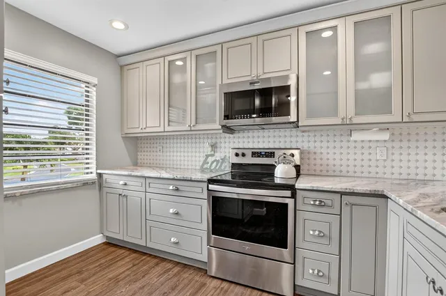 a kitchen with cabinets stainless steel appliances and wooden floor