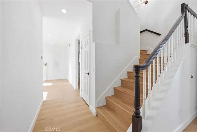 a view of an empty room with cabinet and wooden floor