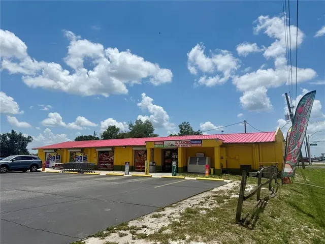 a view of a large white building in front of a house