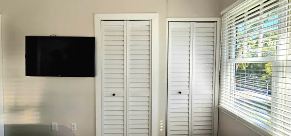 a bedroom with a bed and two windows