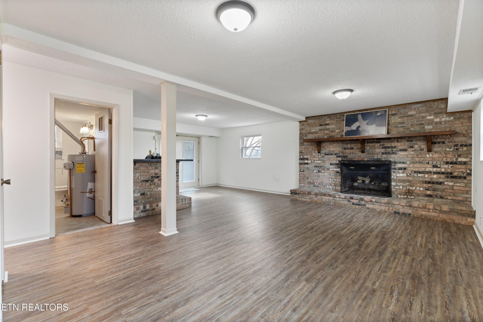 912 Naples Road Knoxville, TN 37923 - Photo 32 of 49 an empty room with wooden floor and a fireplace