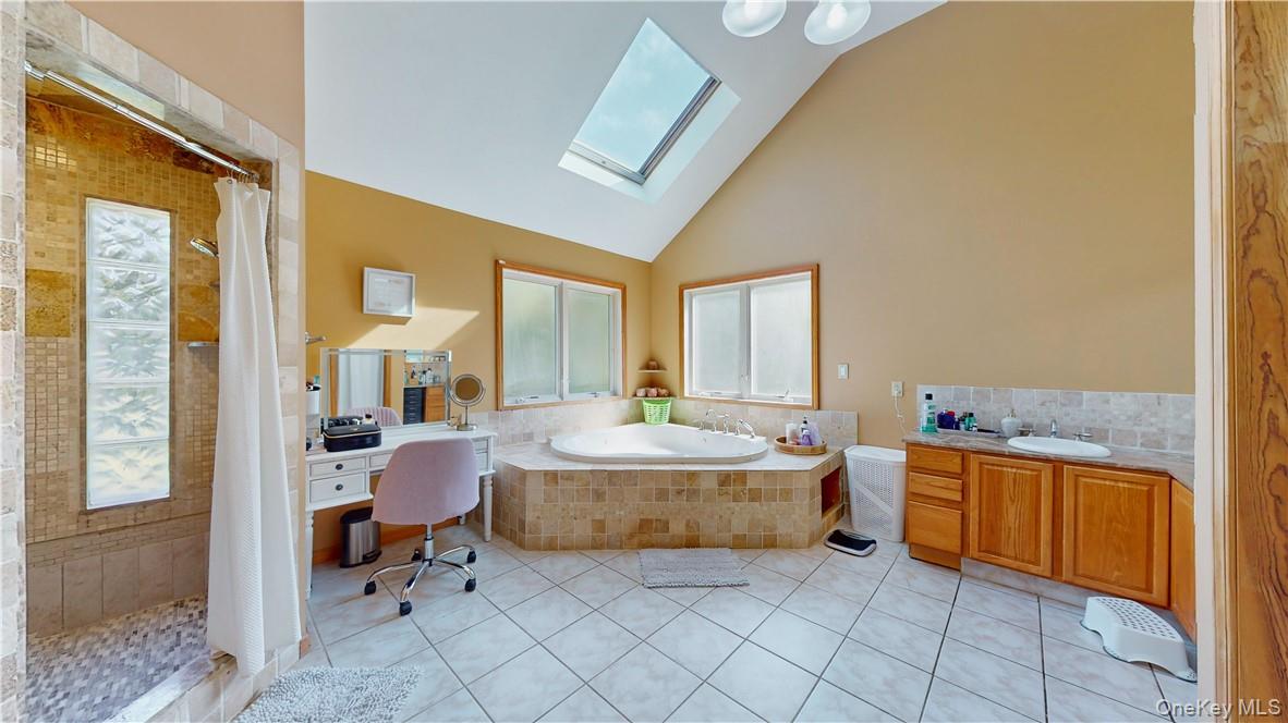 75 Monahan Road Port Jervis, NY 12771 - Photo 27 of 36 Bathroom featuring tile patterned flooring, shower with separate bathtub, vanity, and a skylight