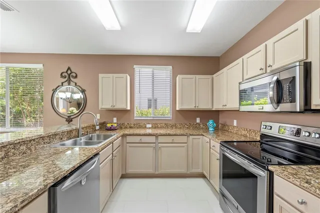 a kitchen with stainless steel appliances granite countertop a stove top oven a sink dishwasher a dining table and chairs
