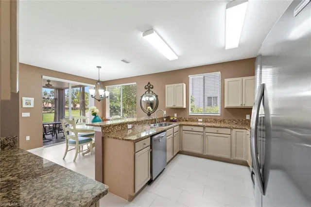 a kitchen with granite countertop a sink stainless steel appliances and a window