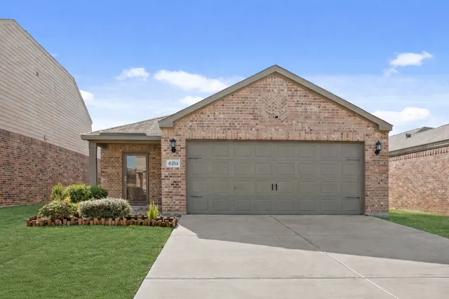 a front view of a house with a garden and plants