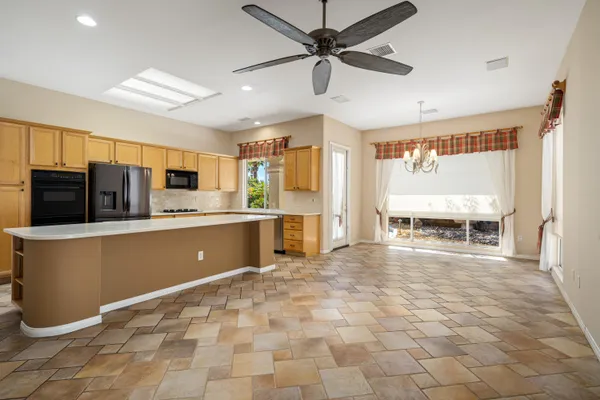 a kitchen with stainless steel appliances a stove a refrigerator a sink and white cabinets