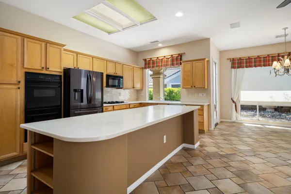 a view of a hallway with windows and chandelier