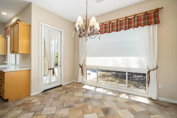 an empty room with windows and chandelier fan