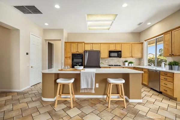 a kitchen with stainless steel appliances granite countertop a stove a sink and a refrigerator