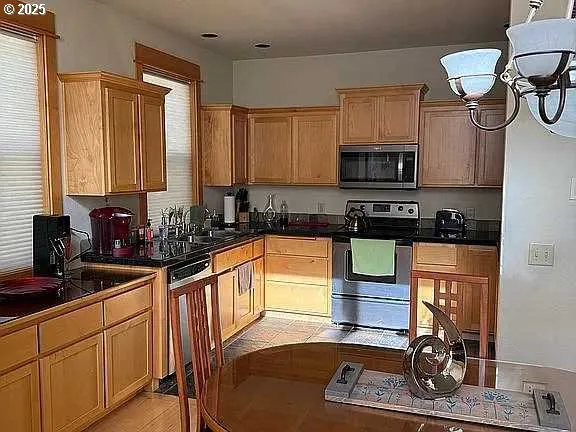 a kitchen with stainless steel appliances granite countertop a stove a sink and a microwave