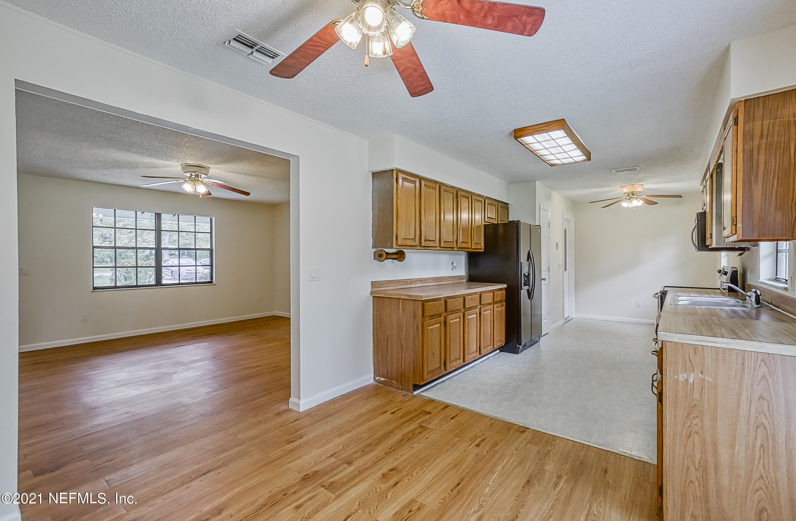 54212 Armstrong Road Callahan, FL 32011 - Photo 14 of 47 a kitchen with kitchen island granite countertop a sink appliances cabinets and a counter top space