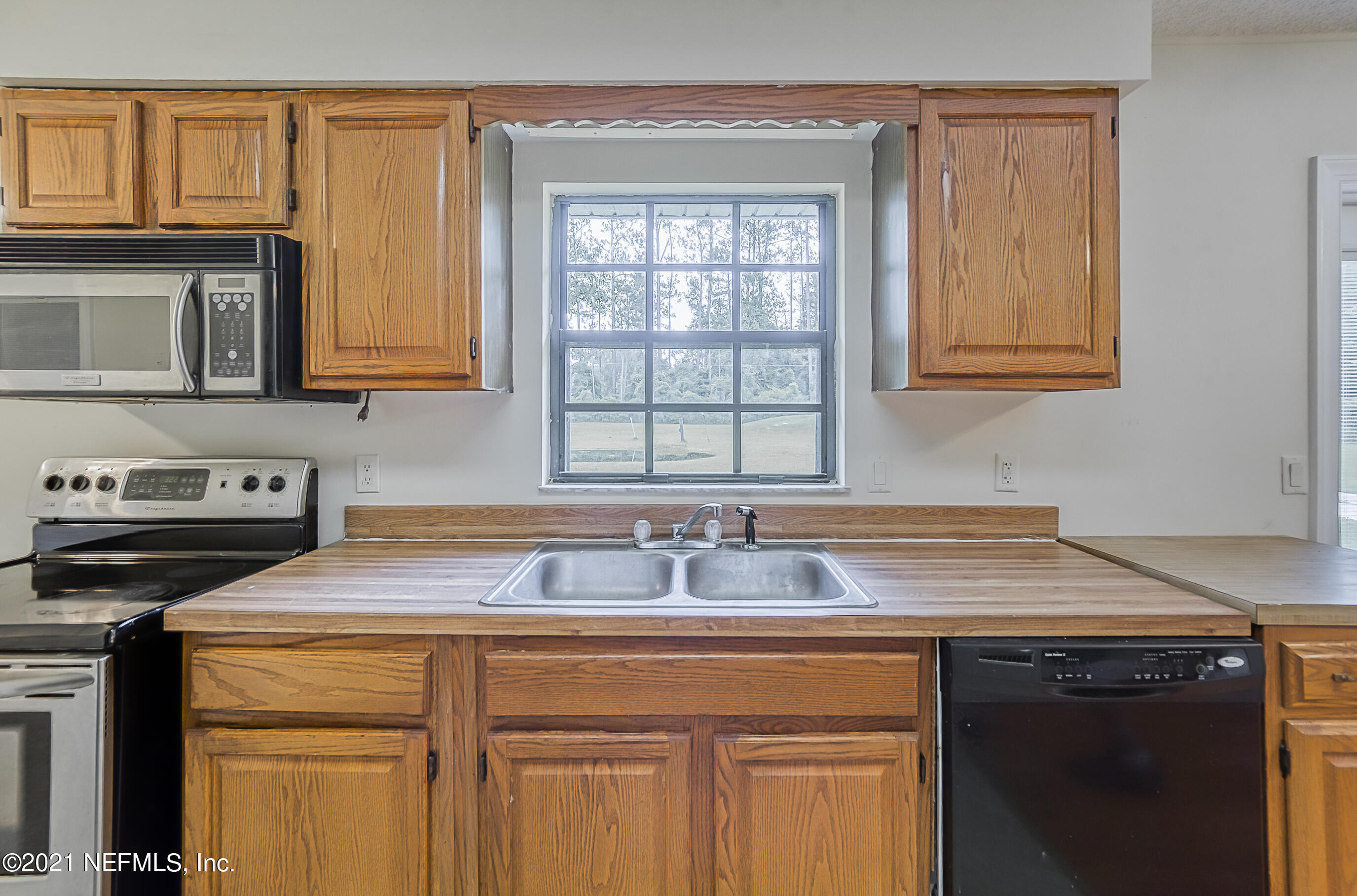 54212 Armstrong Road Callahan, FL 32011 - Photo 16 of 47 a kitchen with granite countertop a sink stove and cabinets