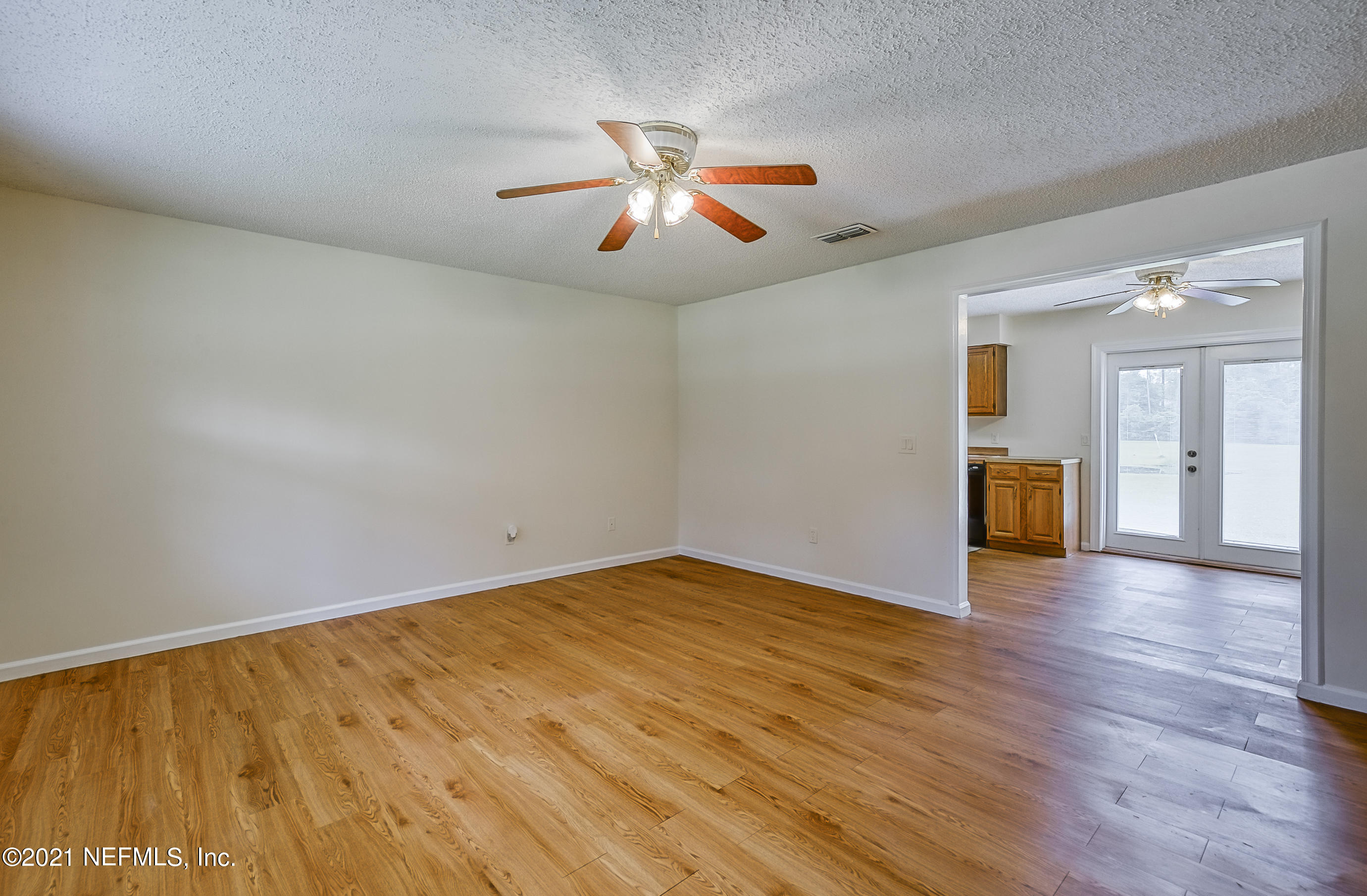 54212 Armstrong Road Callahan, FL 32011 - Photo 18 of 47 an empty room with wooden floor and windows