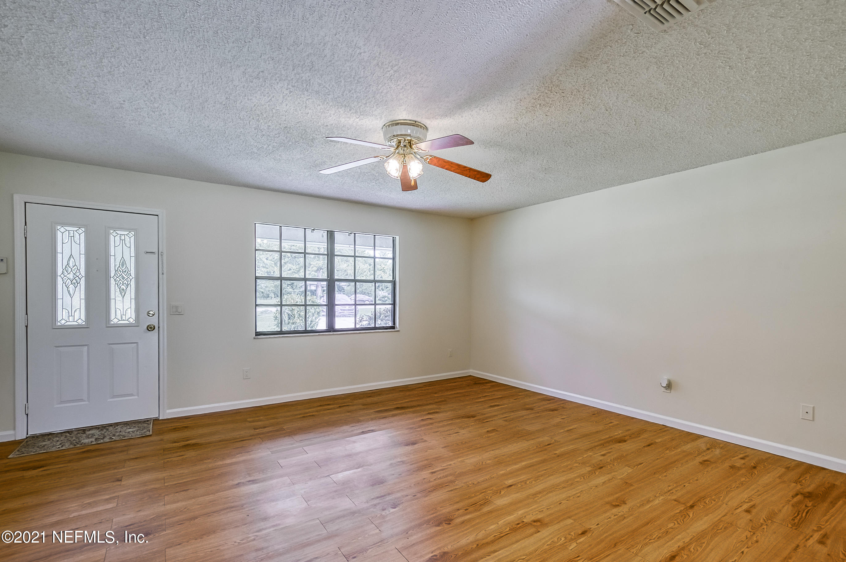 54212 Armstrong Road Callahan, FL 32011 - Photo 21 of 47 a view of an empty room with window and wooden floor