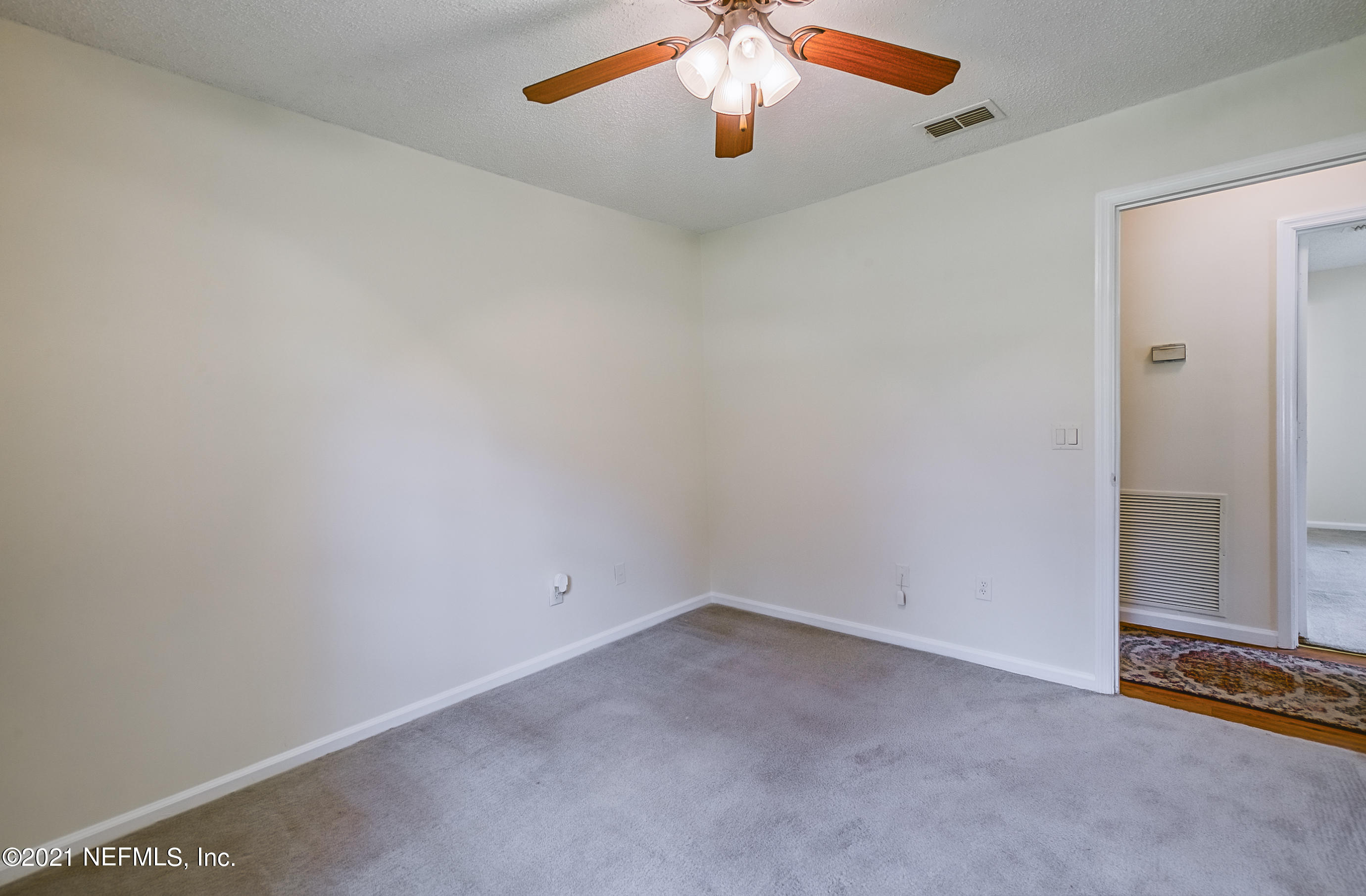 54212 Armstrong Road Callahan, FL 32011 - Photo 35 of 47 an empty room with chandelier fan and windows