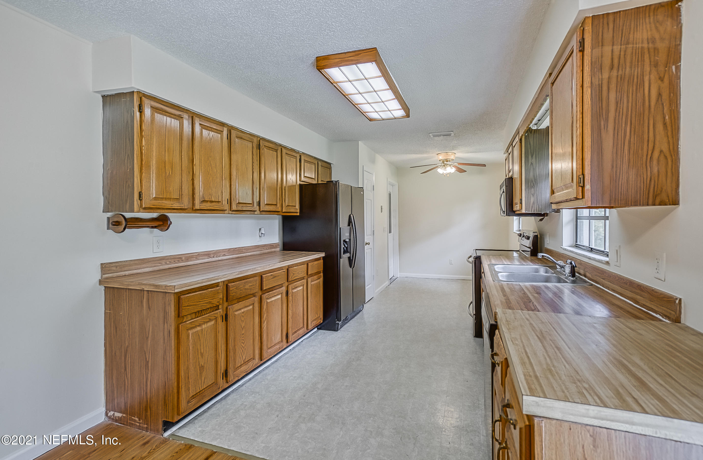 54212 Armstrong Road Callahan, FL 32011 - Photo 7 of 47 a kitchen with granite countertop a sink stove and refrigerator