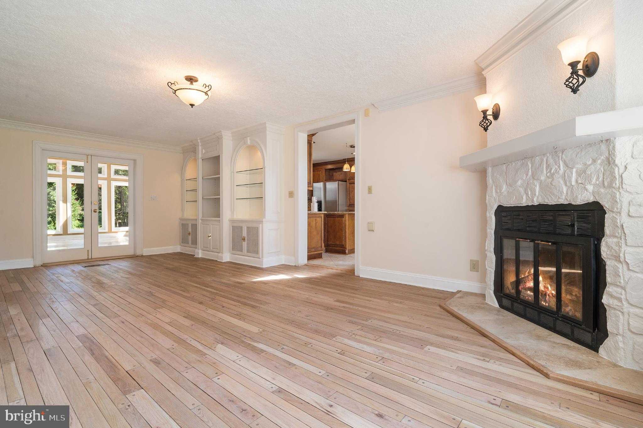 15729 Holly Grove Road Silver Spring, MD 20905 - Photo 28 of 83 a view of an empty room with wooden floor fireplace and a window