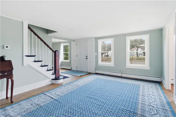 a view of an empty room with window and stairs