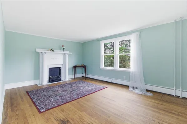 an empty room with windows and fireplace