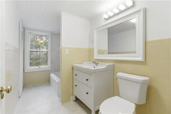 a bathroom with a toilet a sink and mirror