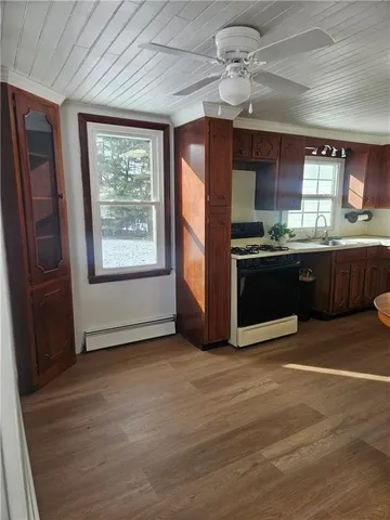a view of kitchen with granite countertop cabinets and refrigerator