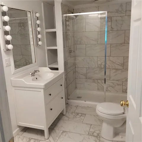 a bathroom with a sink a toilet and shower