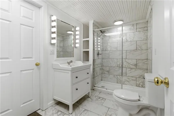 a bathroom with a double vanity sink toilet and shower