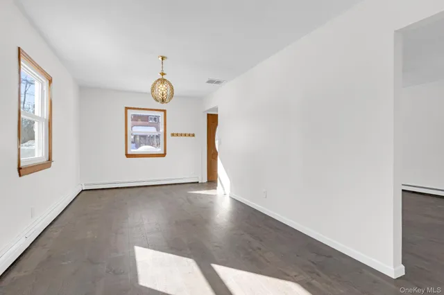 an empty room with a window and a ceiling fan