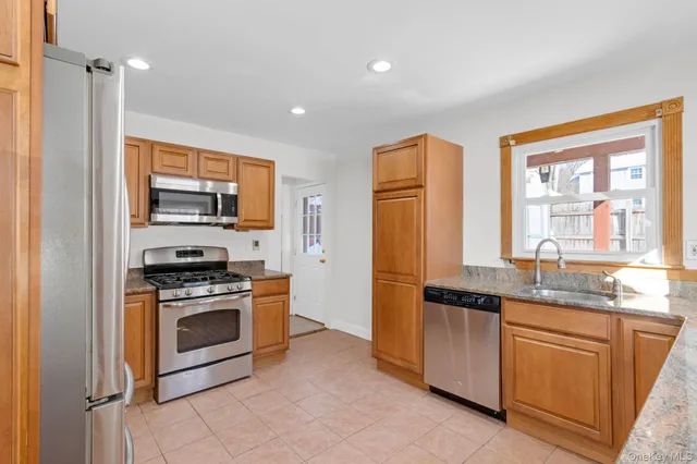a kitchen with stainless steel appliances granite countertop a stove a sink and a refrigerator