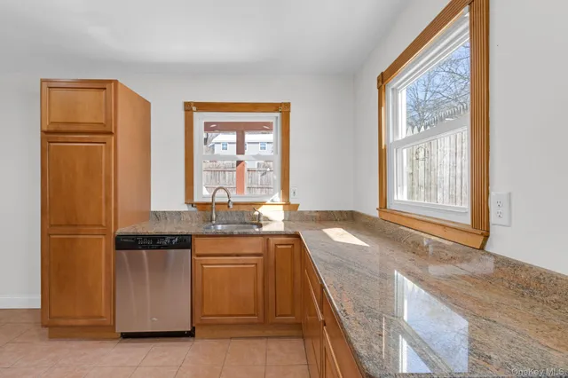 a kitchen with granite countertop cabinets stainless steel appliances a sink and a window