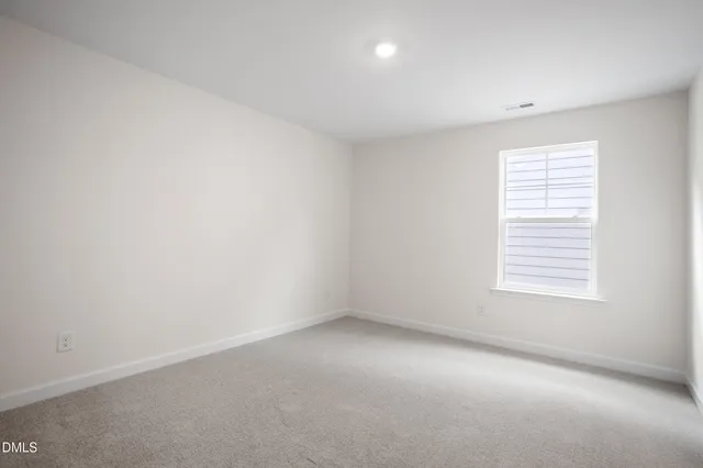 an empty room with closet and windows