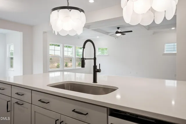 a kitchen with granite countertop a stove a cabinets and wooden floor