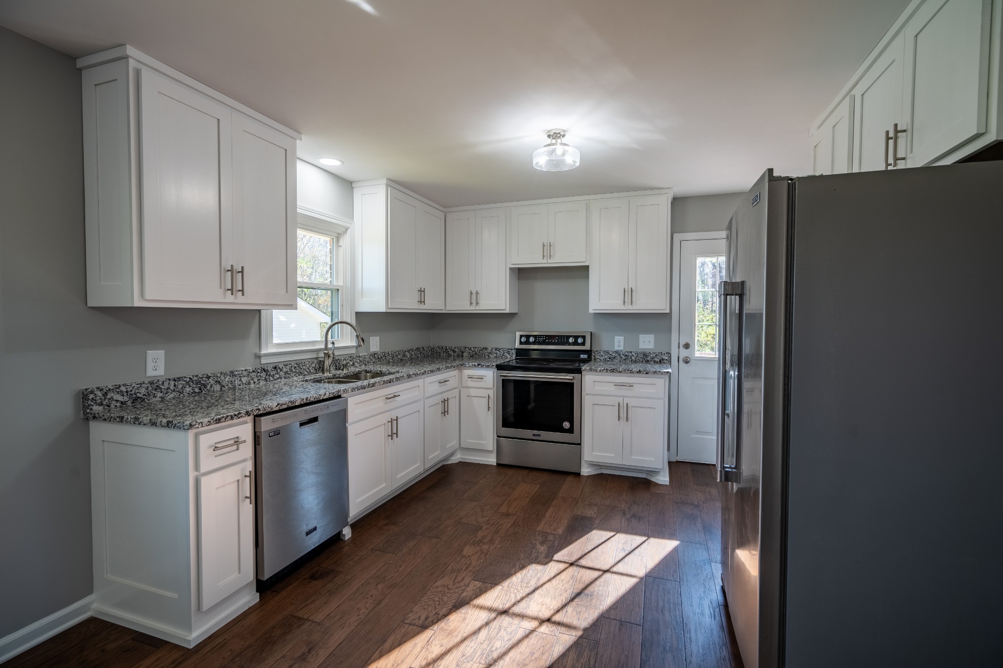 3993 Clanton Road Lawrenceburg, TN 38464 - Photo 12 of 24 a kitchen with granite countertop white cabinets and refrigerator