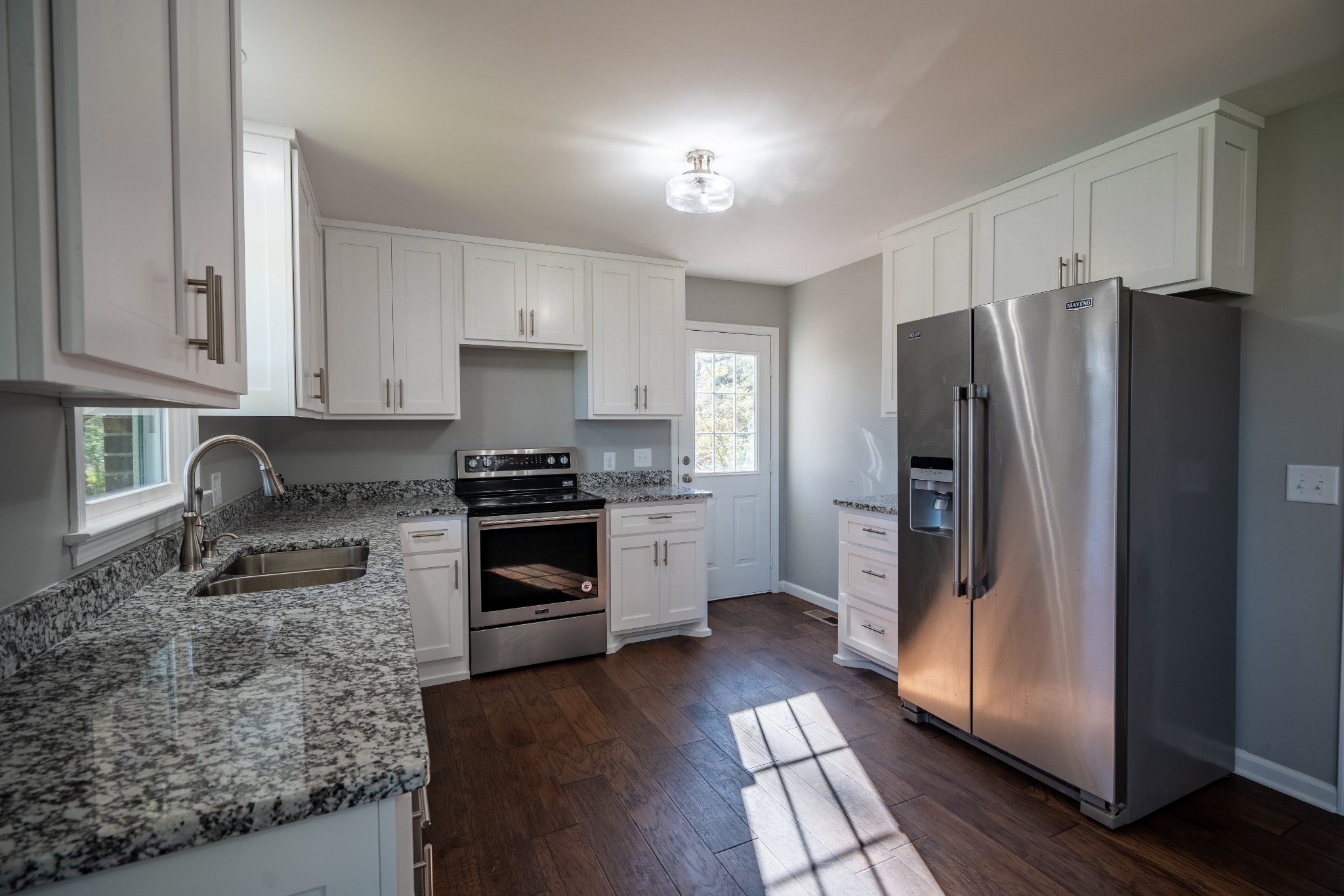 3993 Clanton Road Lawrenceburg, TN 38464 - Photo 14 of 24 a kitchen with granite countertop a refrigerator and a stove top oven