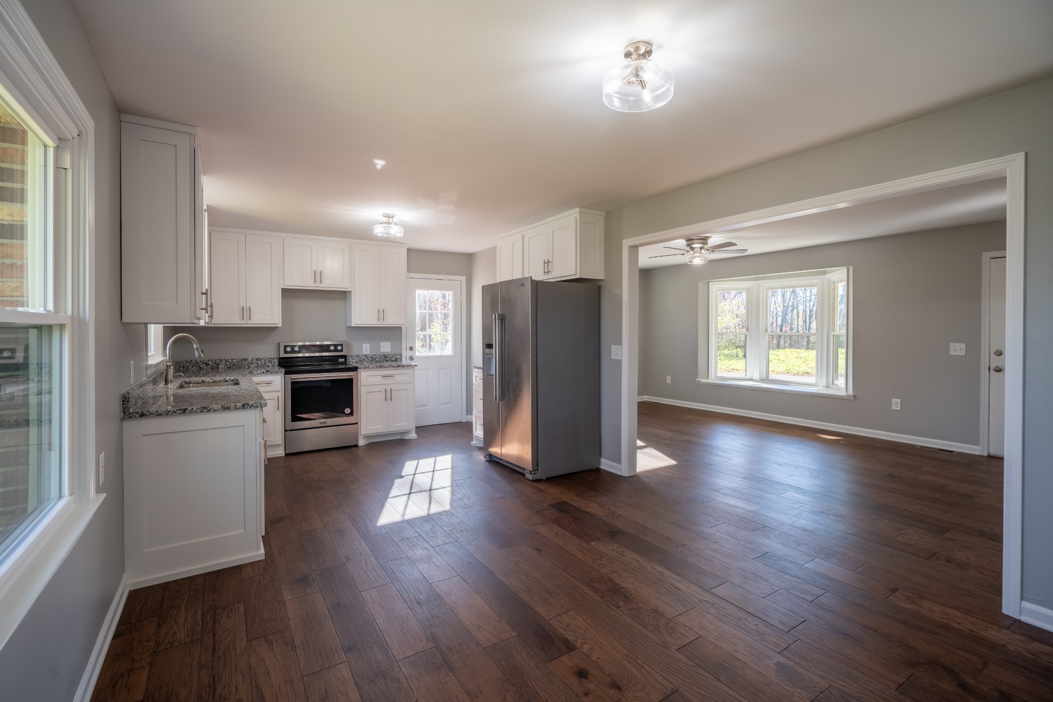 3993 Clanton Road Lawrenceburg, TN 38464 - Photo 16 of 24 a kitchen with stainless steel appliances wooden floors and white cabinets