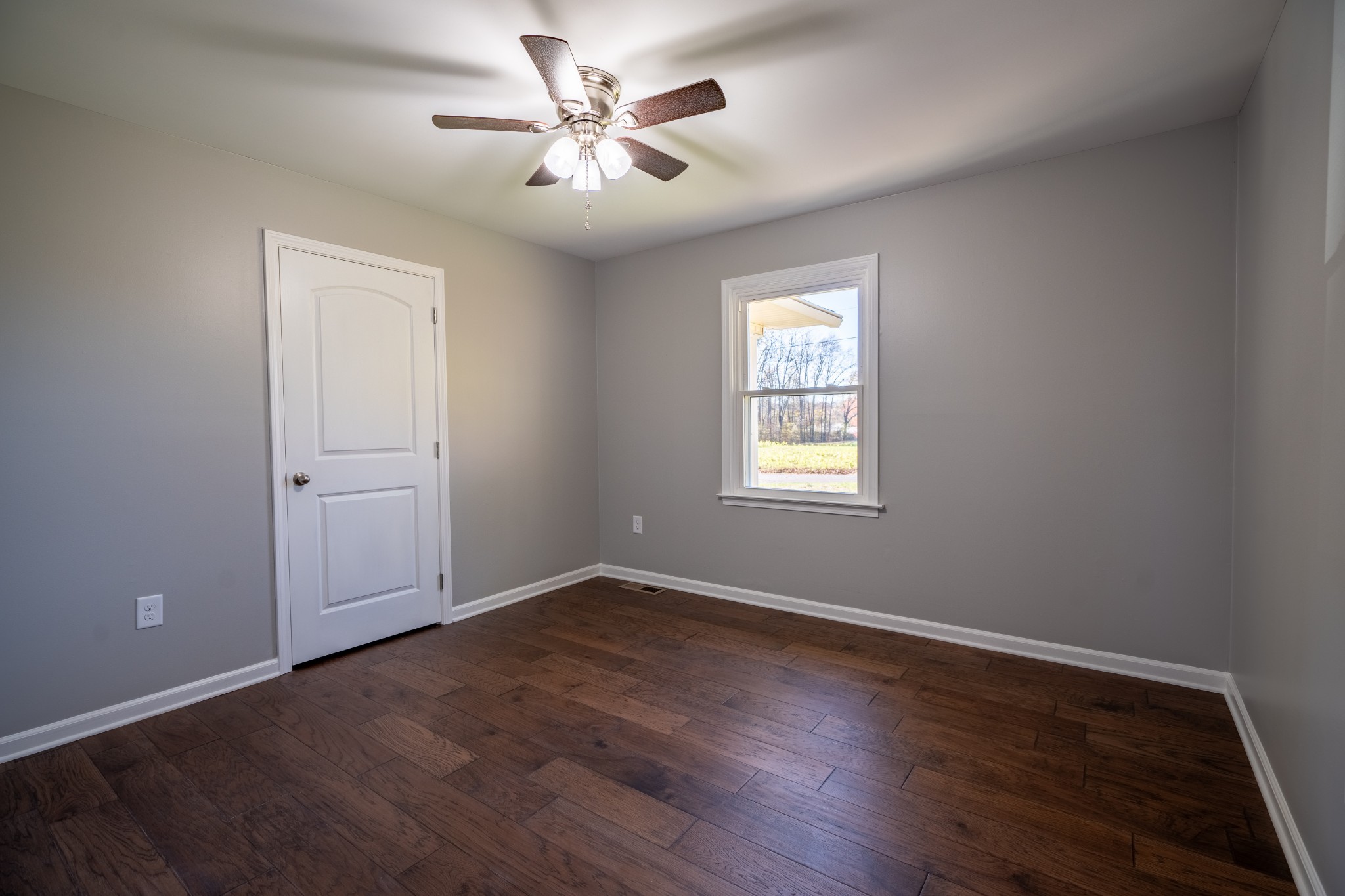 3993 Clanton Road Lawrenceburg, TN 38464 - Photo 18 of 24 an empty room with wooden floor and a ceiling fan
