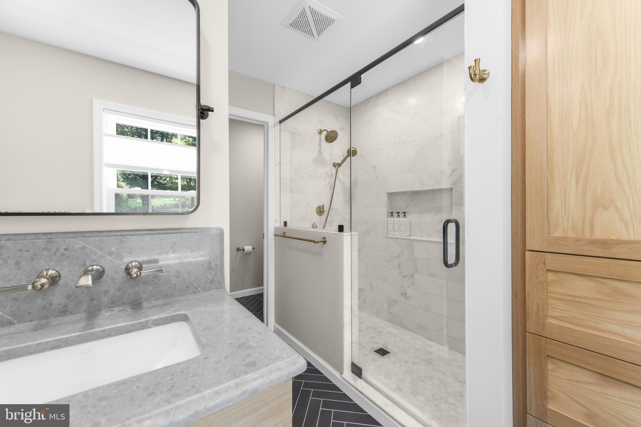530 Arrowhead Trail Sinking Spring, PA 19608 - Photo 24 of 52 a bathroom with a granite countertop sink a mirror a glass door and shower