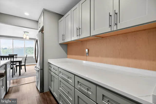 an entryway with wooden floor and cabinets