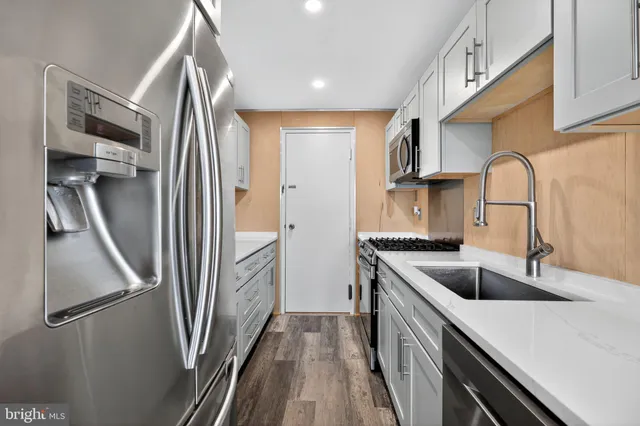 a kitchen with stainless steel appliances granite countertop a refrigerator and a sink