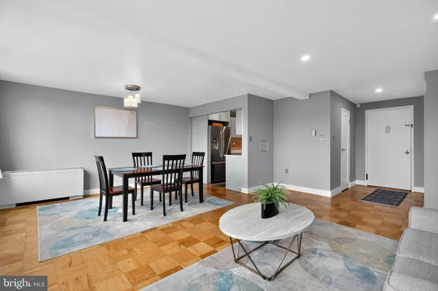 a living room with furniture a dining table and a potted plant