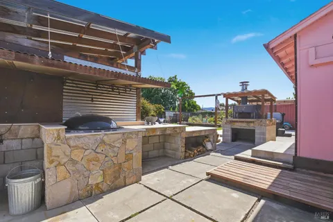a view of a patio with table and chairs with wooden floor and fence