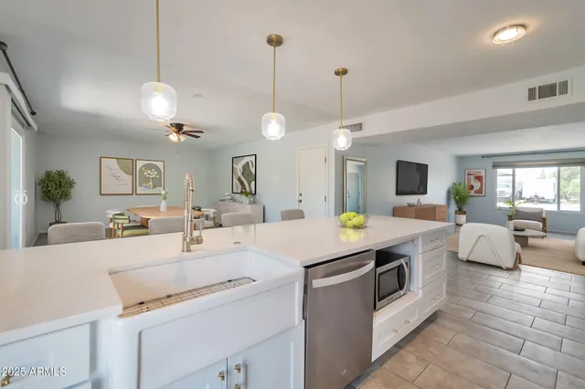 a kitchen that has a lot of white cabinets and couches