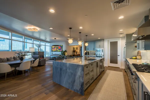 a large kitchen with lots of counter space a sink a window and chairs