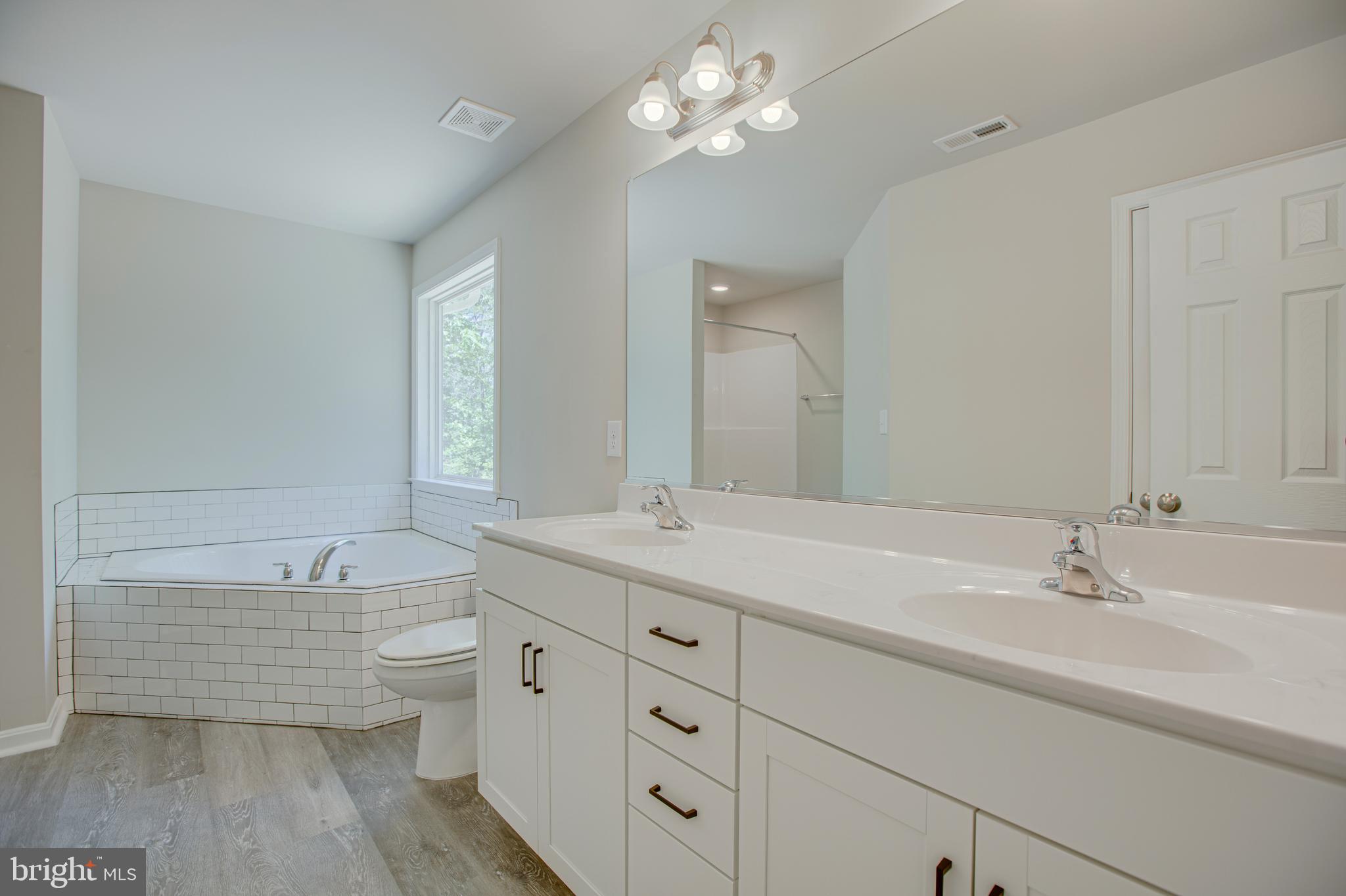 282 Circle Lane Colonial Beach, VA 22443 - Photo 17 of 57 a bathroom with a double vanity sink a mirror and a bathtub