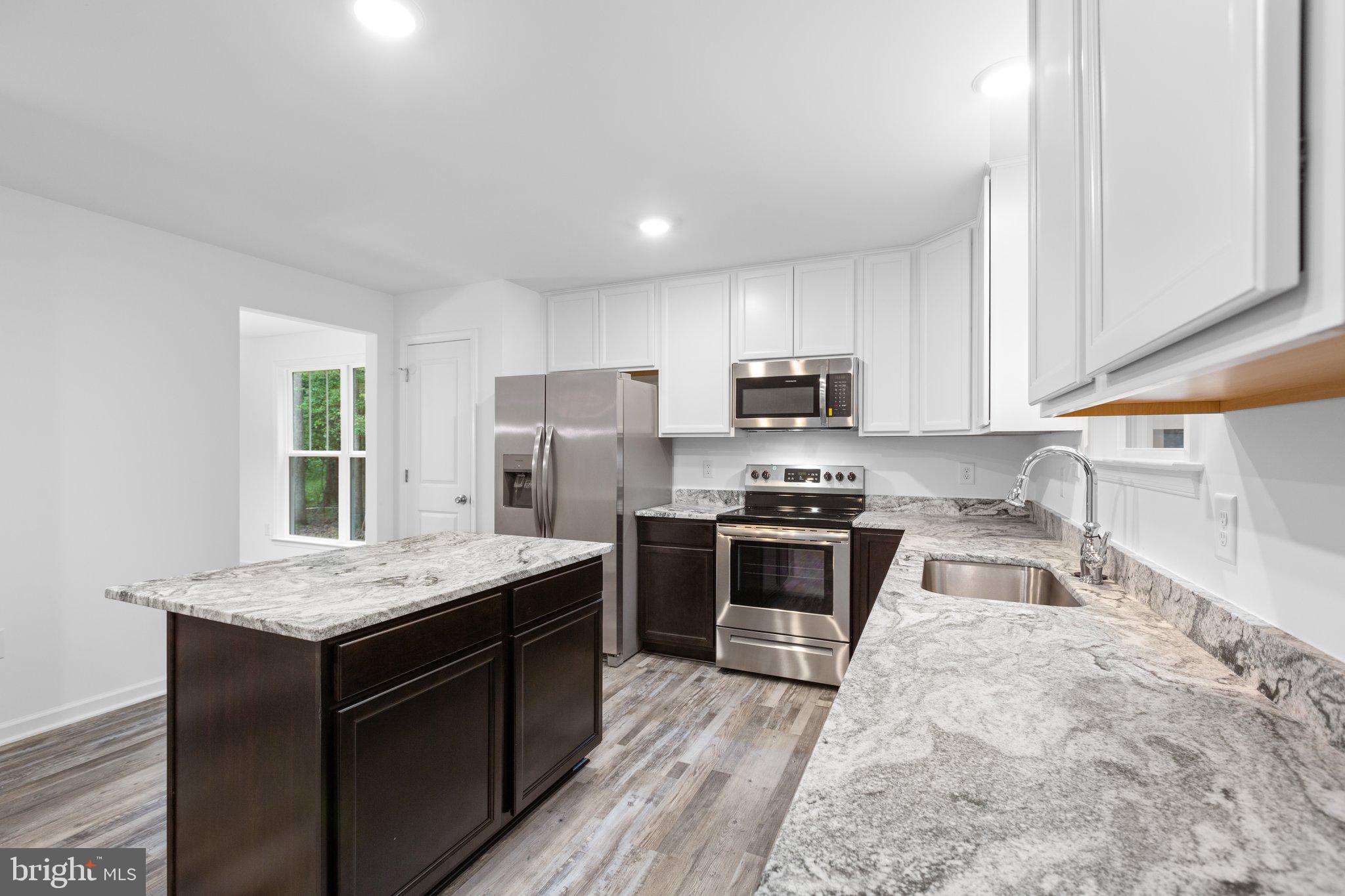 282 Circle Lane Colonial Beach, VA 22443 - Photo 39 of 57 a kitchen with granite countertop stainless steel appliances a sink dishwasher a refrigerator a stove top oven and a counter space