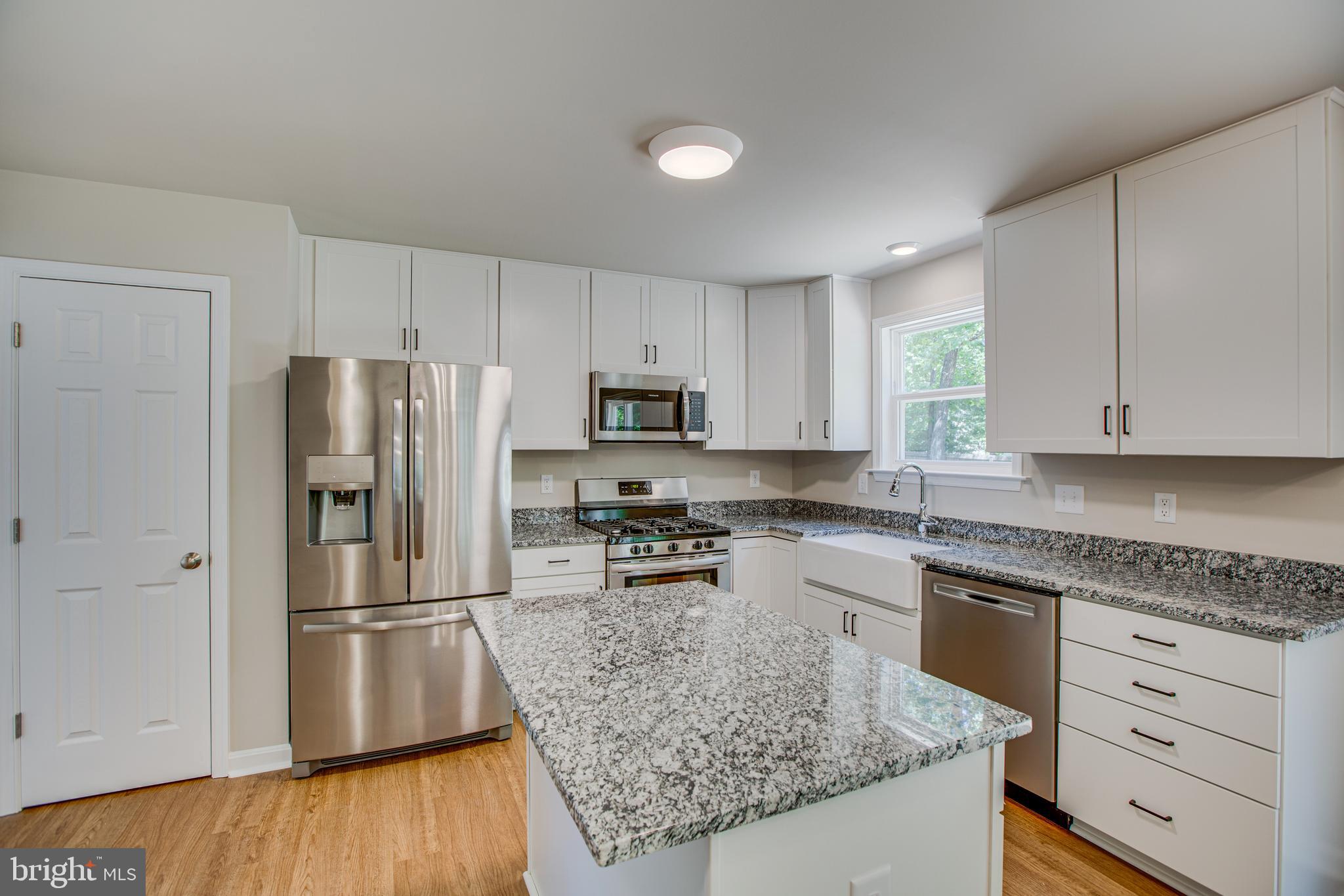 282 Circle Lane Colonial Beach, VA 22443 - Photo 5 of 57 a kitchen with granite countertop a refrigerator a sink dishwasher a stove with wooden floor