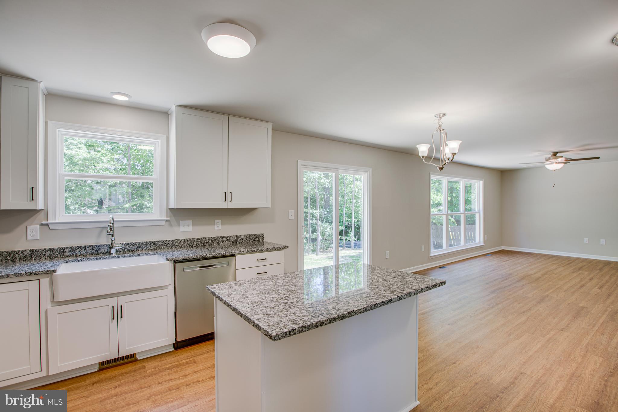 282 Circle Lane Colonial Beach, VA 22443 - Photo 7 of 57 a kitchen with granite countertop kitchen island a sink appliances cabinets and a large window