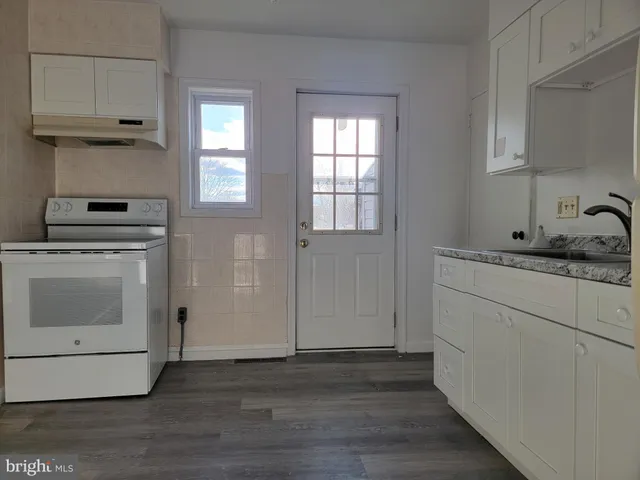 a kitchen with cabinets appliances and wooden floor