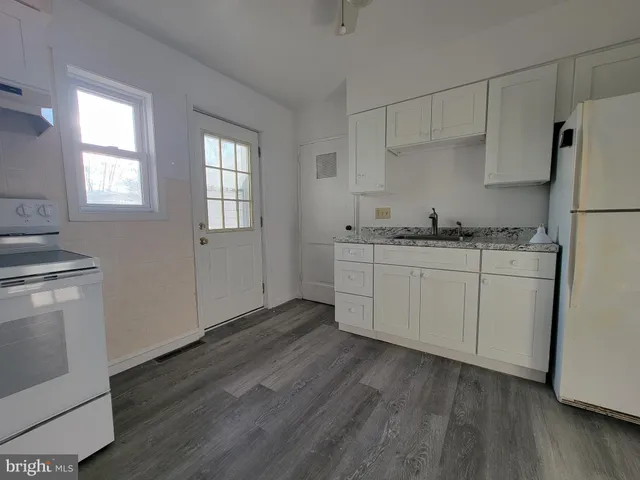 a kitchen with stainless steel appliances a sink cabinets and wooden floor